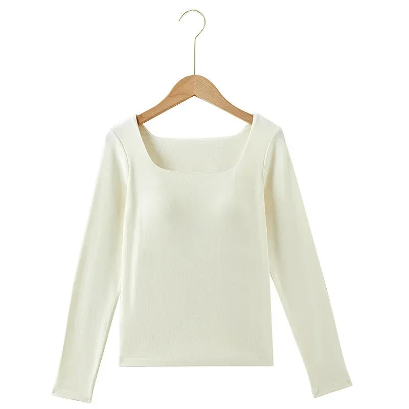 White long-sleeve shirt on a wooden hanger against a white background
