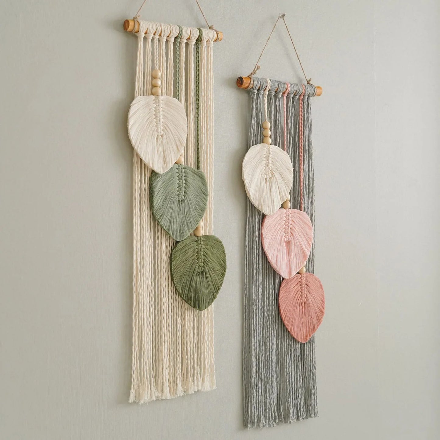 Two wall hangings with leaf-shaped ceramic pieces on a light gray background