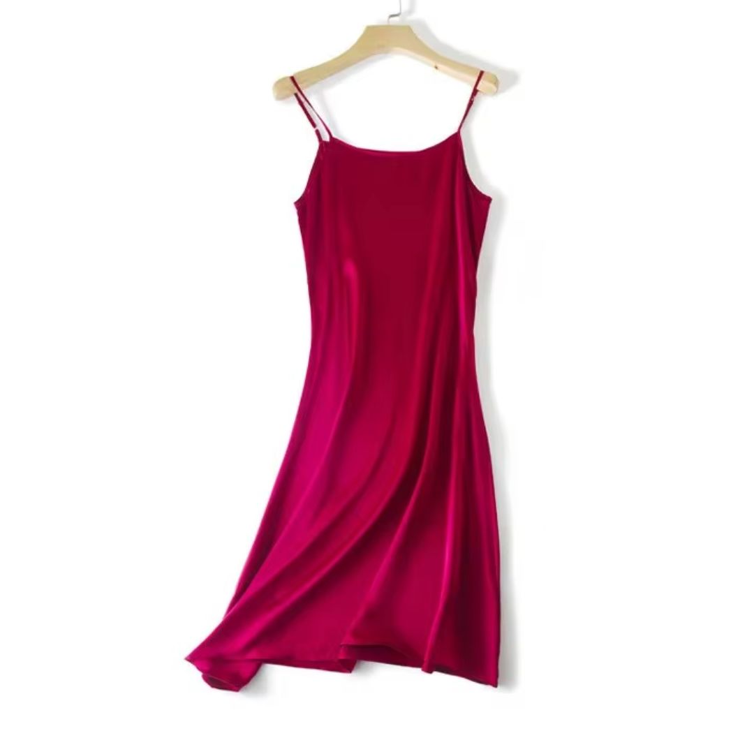 Red slip dress on a wooden hanger against a white background