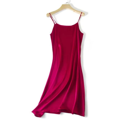 Red slip dress on a wooden hanger against a white background