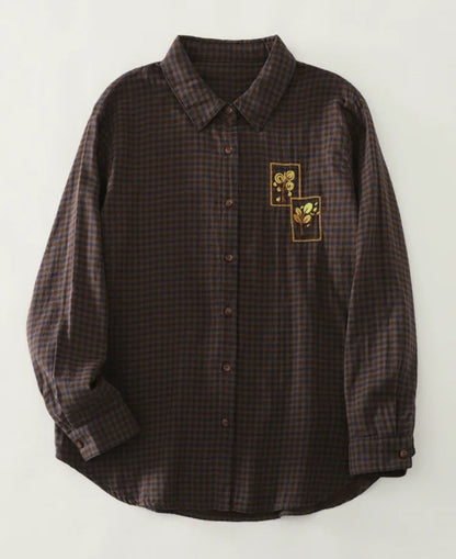 Plaid shirt with embroidered design on a white background