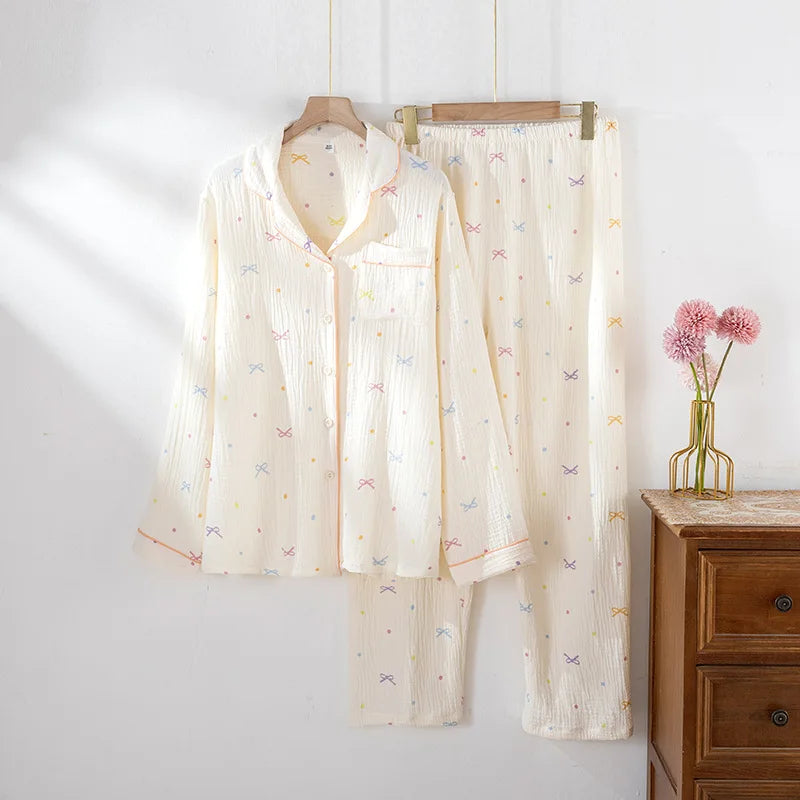 Shirt pajama set hanging on a rack against a white wall with a wooden dresser and pink flowers in the background.
