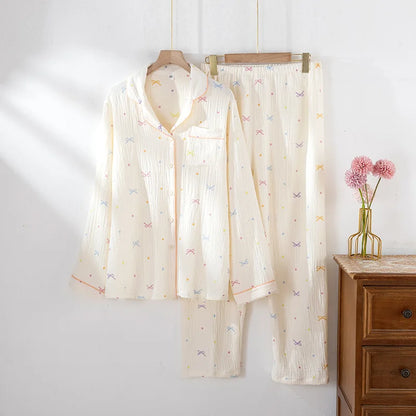 Shirt pajama set hanging on a rack against a white wall with a wooden dresser and pink flowers in the background.