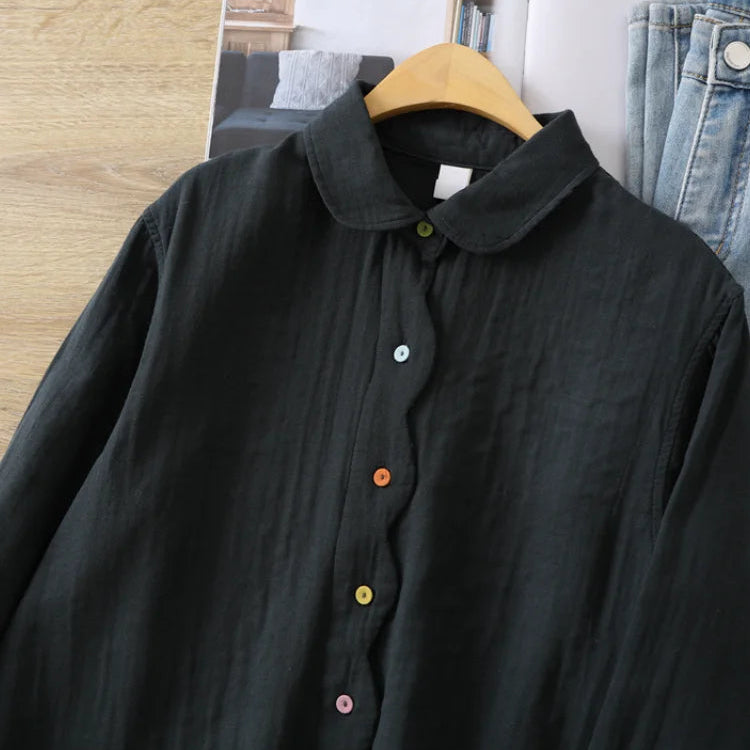Black button-up shirt on a hanger with jeans in the background