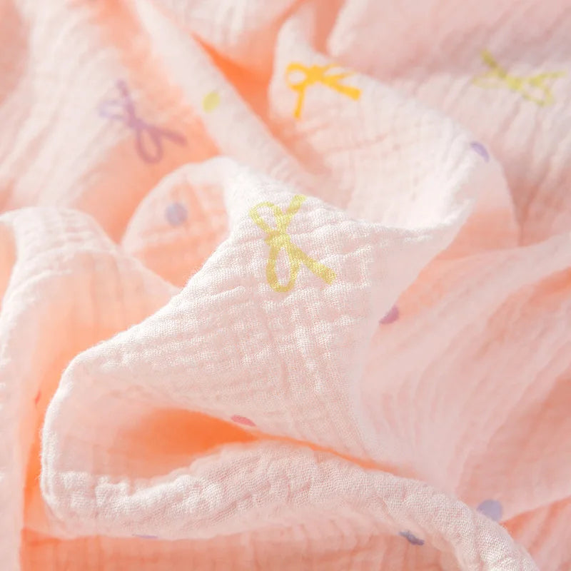 Close-up of a soft, textured fabric with colorful patterns on a light pink pyjama.