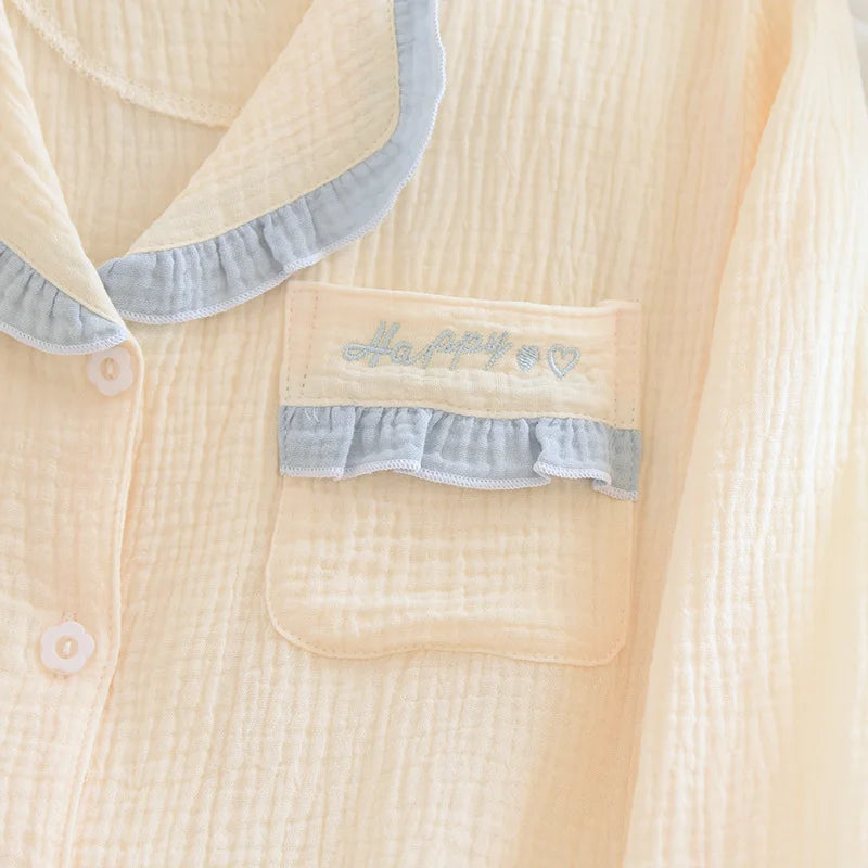 Close-up of a beige textured shirt with ruffled details on the collar and pocket.
