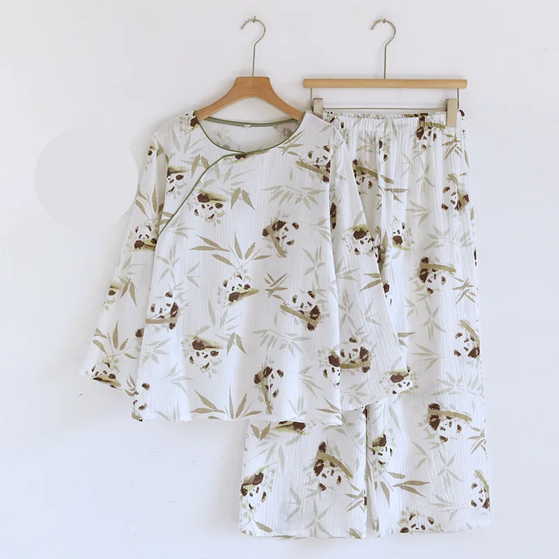 Pajama set with panda pattern on hangers against a white background