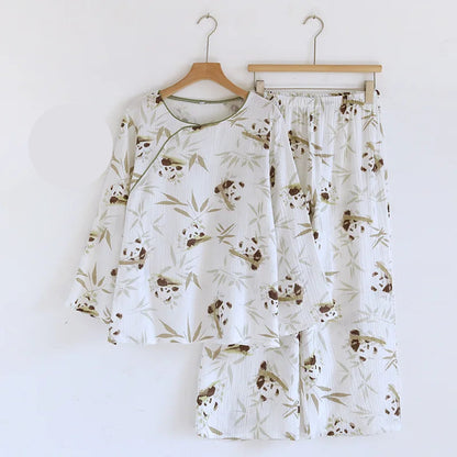 Pajama set with panda pattern on hangers against a white background