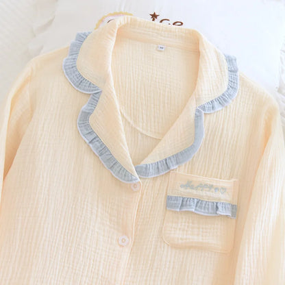 Light yellow pajama top with blue ruffled collar on a white background