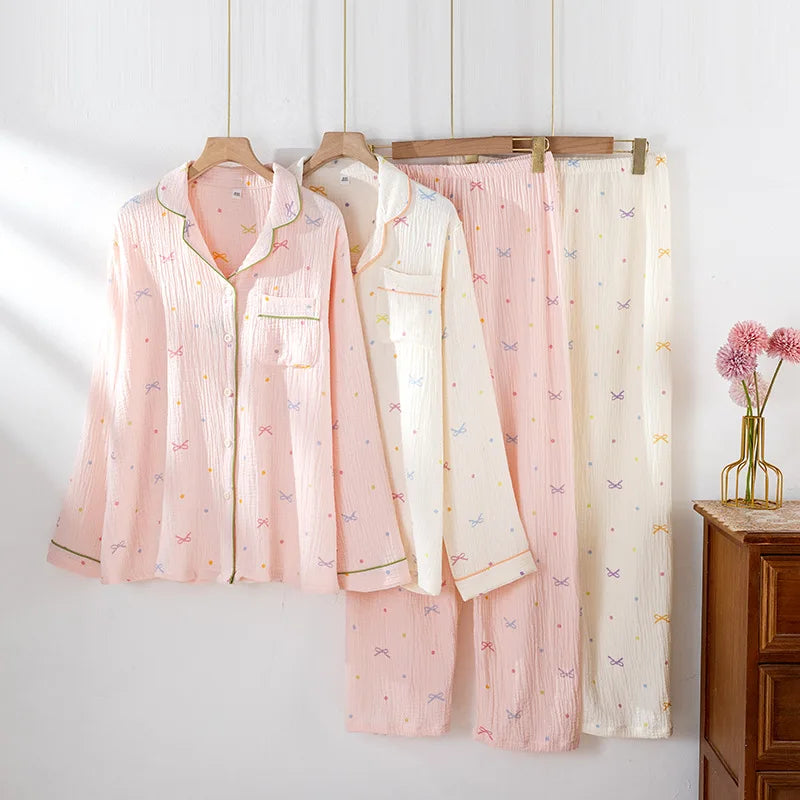 Pink and white pajama sets hanging on a rack against a white wall.