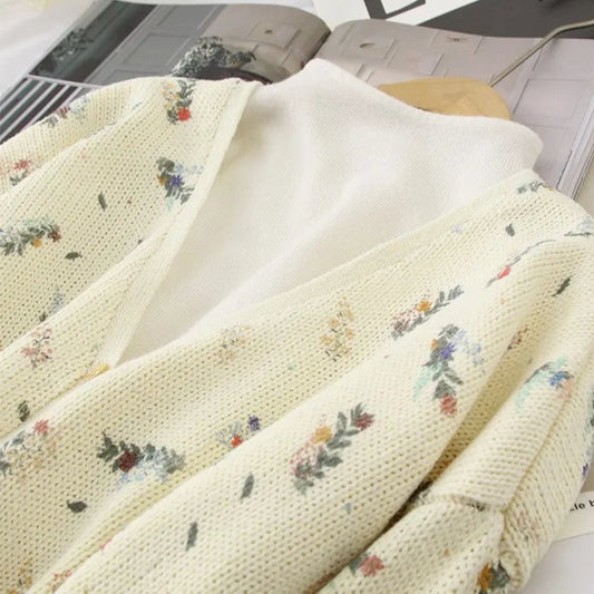 Floral-patterned fabric on a surface with a laptop and magazine in the background