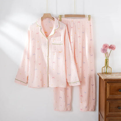 Pink shirt pajama set with floral patterns hanging on a wooden hanger against a white wall.