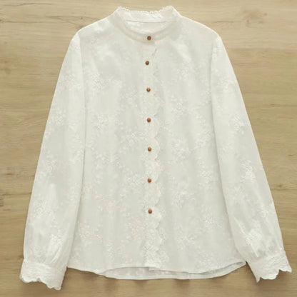 White blouse with buttons on a wooden surface