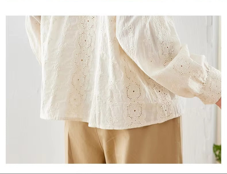 White embroidered blouse with beige pants on a white background