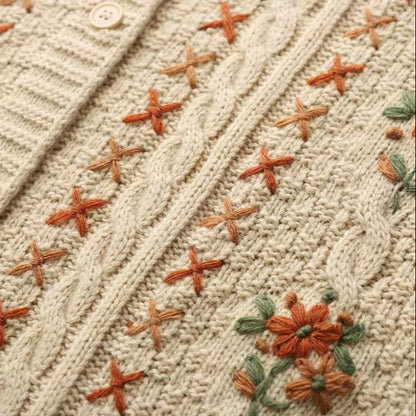 Close-up of a knitted fabric with embroidered starfish and floral patterns.