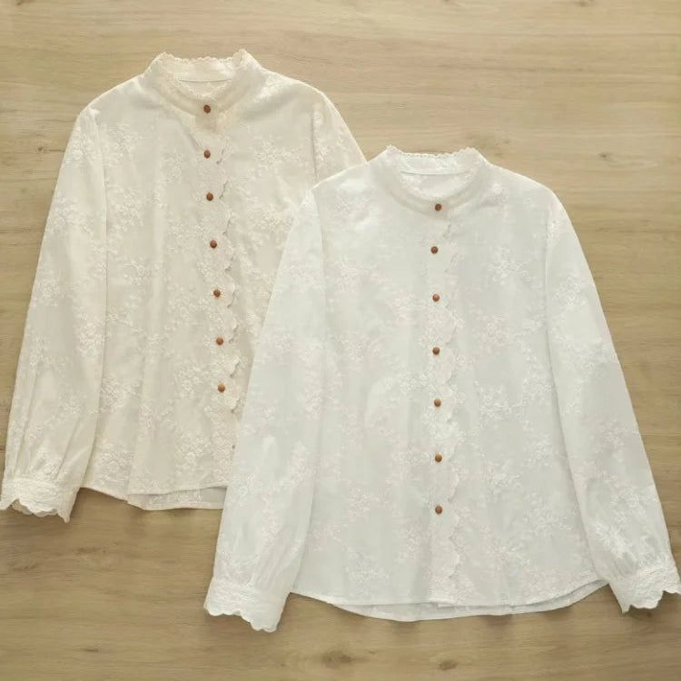 Two white button-up shirts on a wooden surface